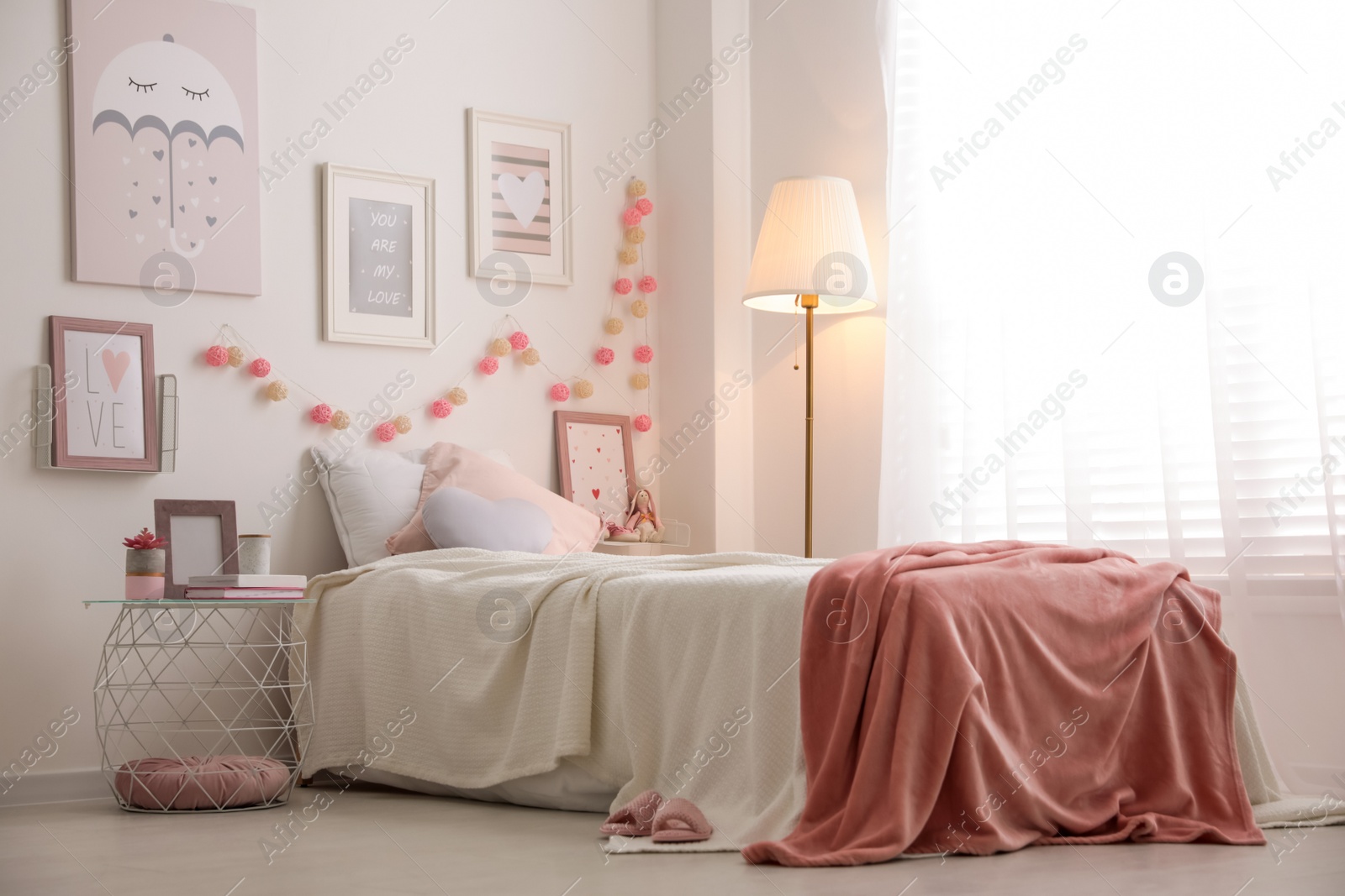 Photo of Modern teenager's room interior with comfortable bed and beautiful pictures