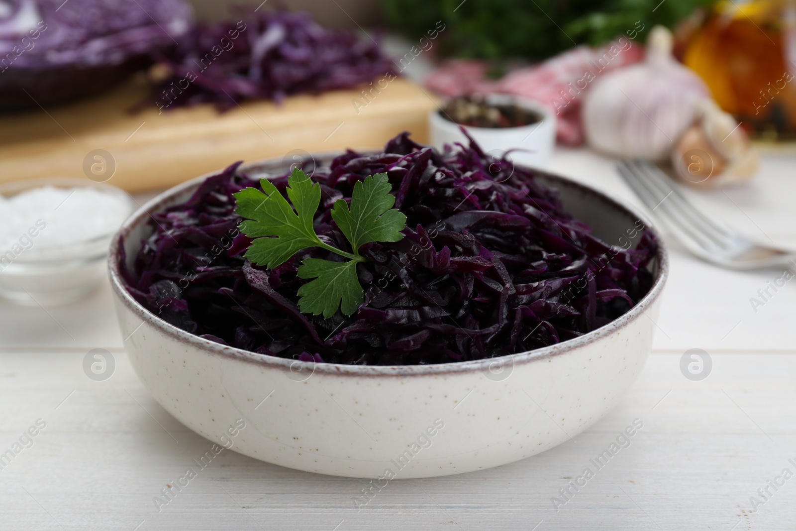 Photo of Tasty red cabbage sauerkraut with parsley on white wooden table