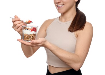 Happy woman eating tasty granola with fresh berries and yogurt on white background, closeup