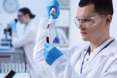 Photo of Scientist dripping sample into test tube in laboratory