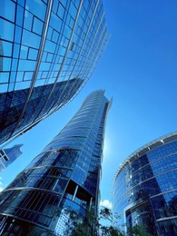 Photo of Low angle view of modern business complex under blue sky