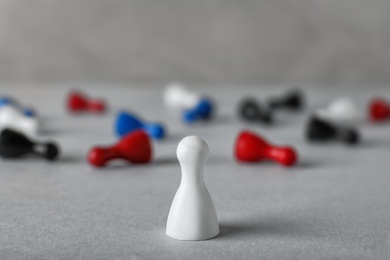 Photo of White pawn standing out from others on table. Be different