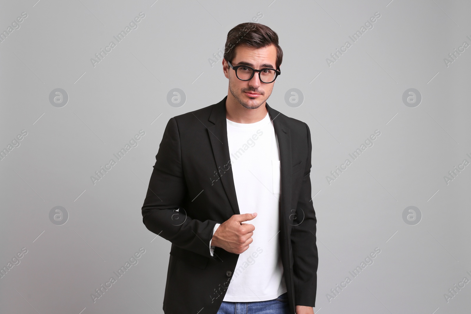 Photo of Handsome young man in casual clothes on grey background