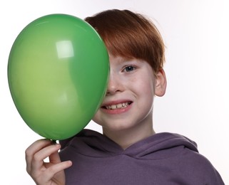 Boy with green balloon on white background