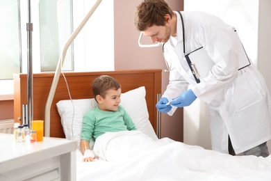 Doctor checking little child's temperature in hospital