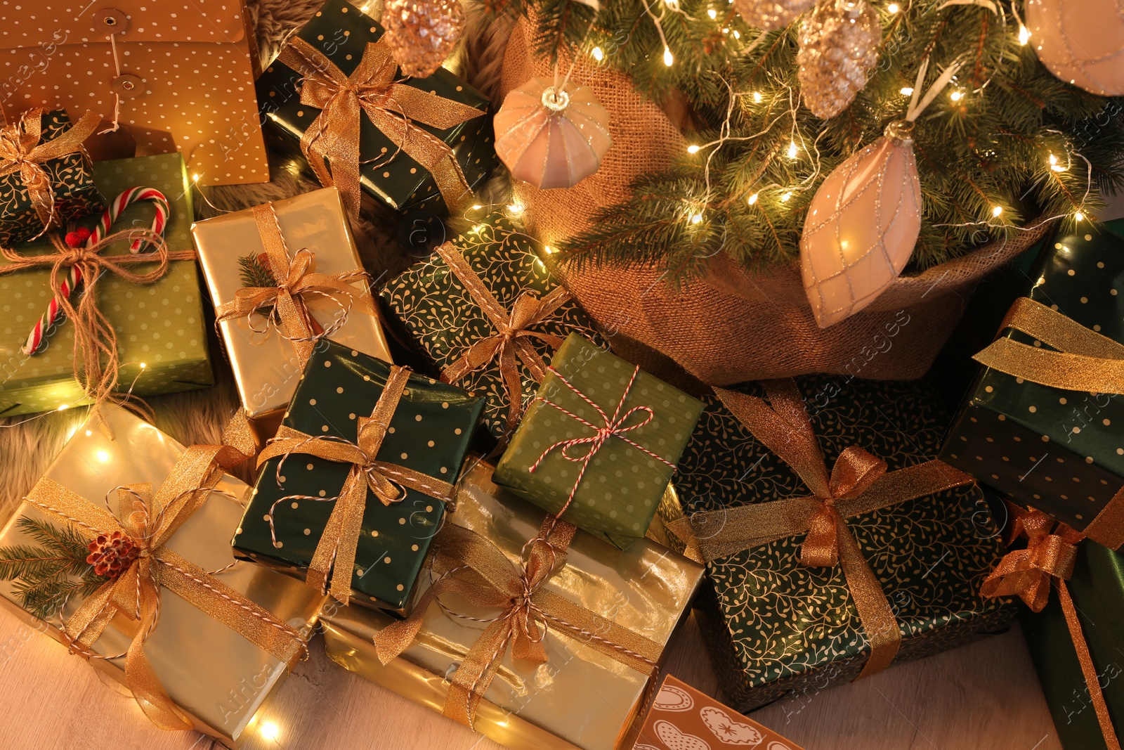 Photo of Many different gifts under Christmas tree indoors, above view