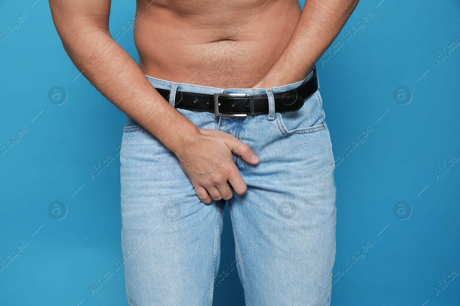 Photo of Man scratching crotch on color background, closeup. Annoying itch