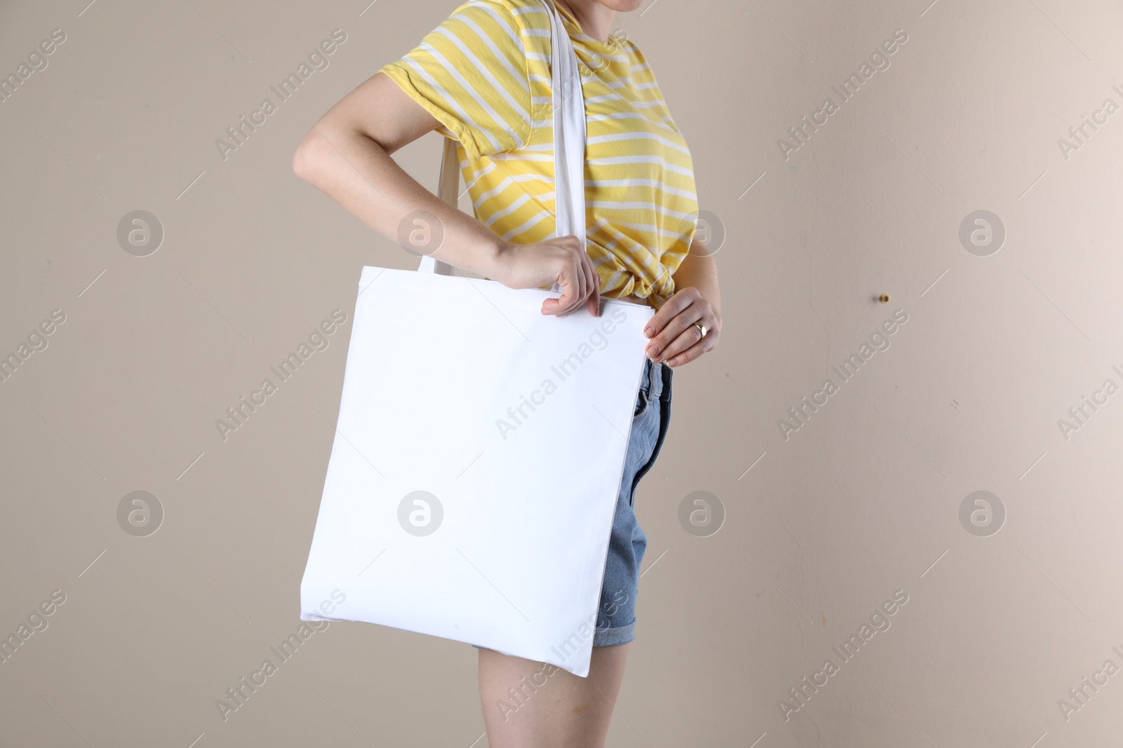 Photo of Woman with textile bag on beige background, closeup. Space for design