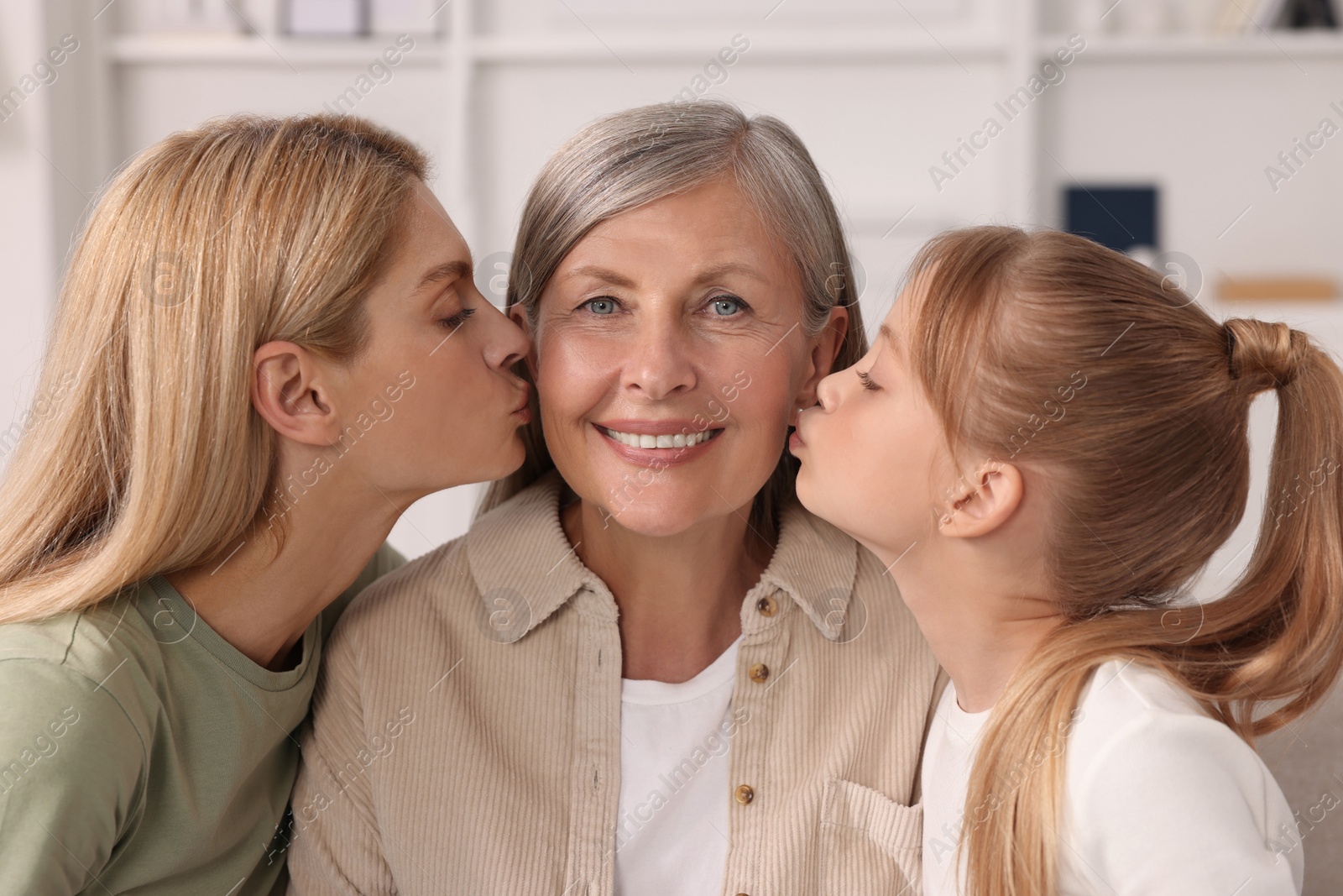 Photo of Three generations. Happy grandmother, her daughter and granddaughter at home