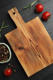 Photo of Wooden cutting board, fresh tomatoes and different spices on grey textured table, flat lay