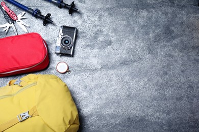 Photo of Flat lay composition with tourist backpack and other different camping equipment on grey background, space for text
