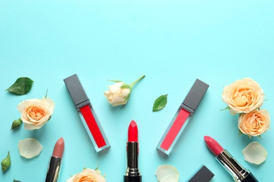 Photo of Flat lay composition with lipsticks and roses on color background