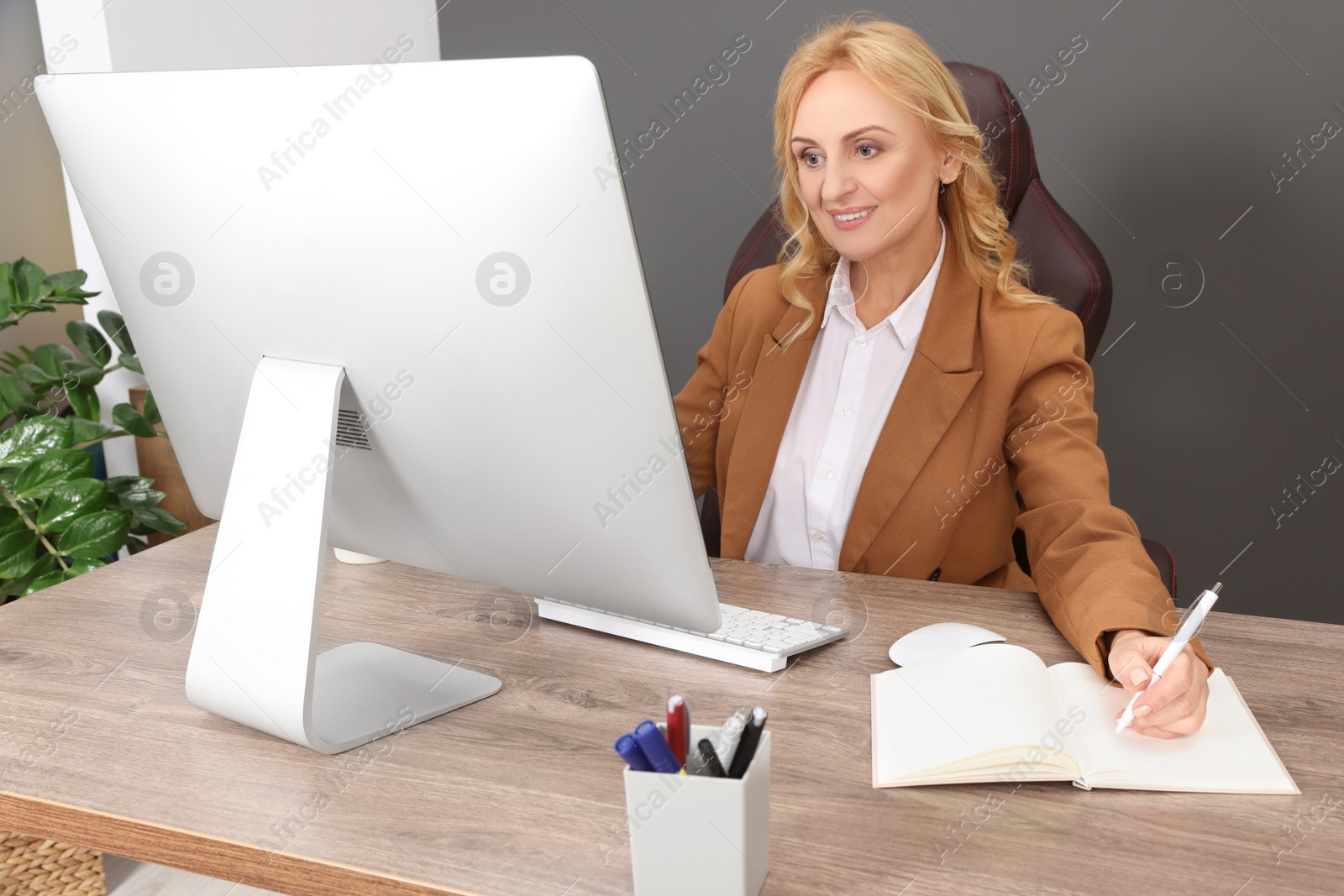 Photo of Lady boss working near computer at desk in office. Successful businesswoman