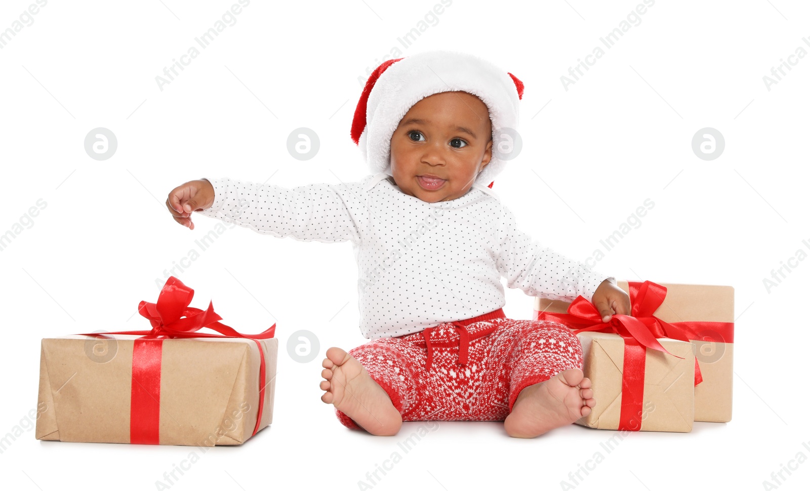 Photo of Festively dressed African-American baby with Christmas gifts on white background