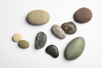 Many different stones on white background, top view