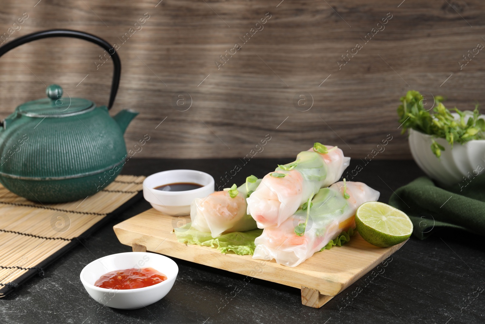 Photo of Delicious spring rolls served on black table