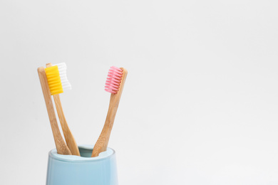 Photo of Bamboo toothbrushes in holder isolated on white