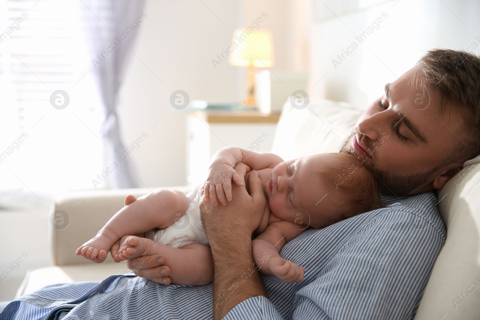 Photo of Father with his newborn son at home