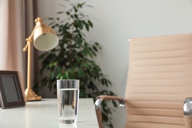 Glass of fresh water on table indoors. Space for text