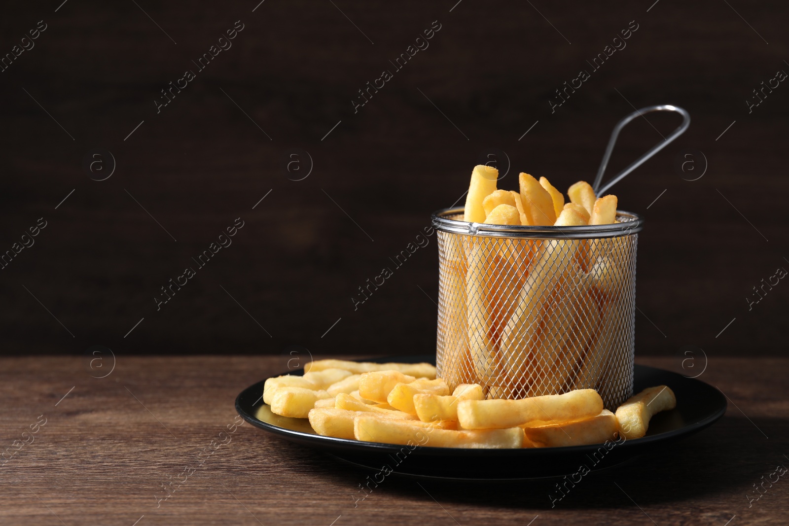 Photo of Delicious French fries on wooden table, space for text