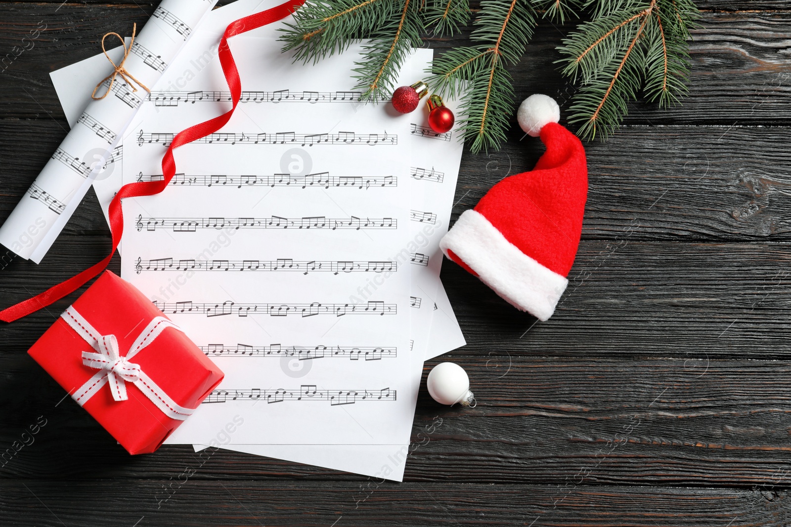 Photo of Flat lay composition with Christmas  decorations and music sheets on wooden background