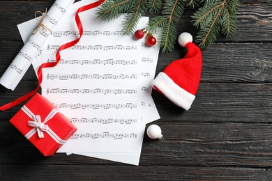 Flat lay composition with Christmas  decorations and music sheets on wooden background