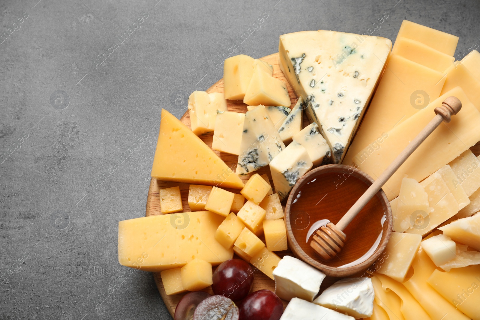 Photo of Different types of delicious cheese and snacks served on grey table, top view