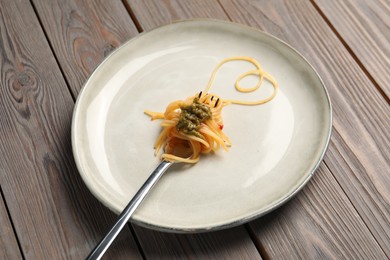 Photo of Heart made with spaghetti and fork on wooden table