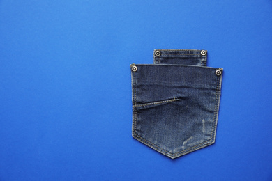Photo of Stylish jeans pockets on blue background, top view. Space for text