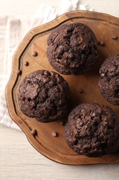 Delicious chocolate muffins on white wooden table, top view