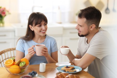 Happy couple having tasty breakfast at home