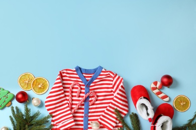Photo of Flat lay composition with cute Christmas baby clothes on light blue background. Space for text
