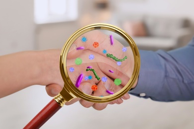 Magnifying glass detecting microbes and business partners shaking hands, closeup