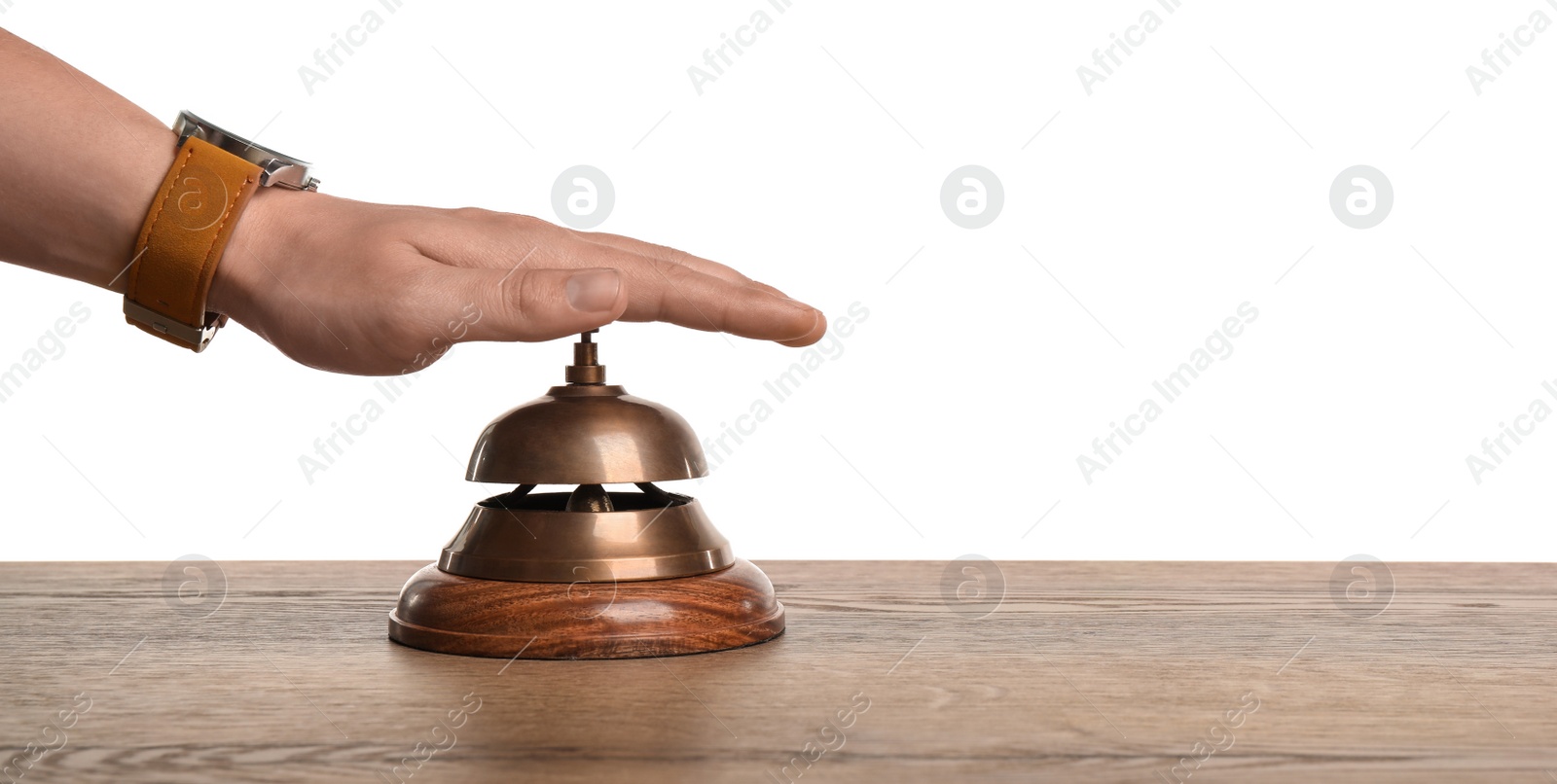 Photo of Man ringing hotel service bell at wooden table