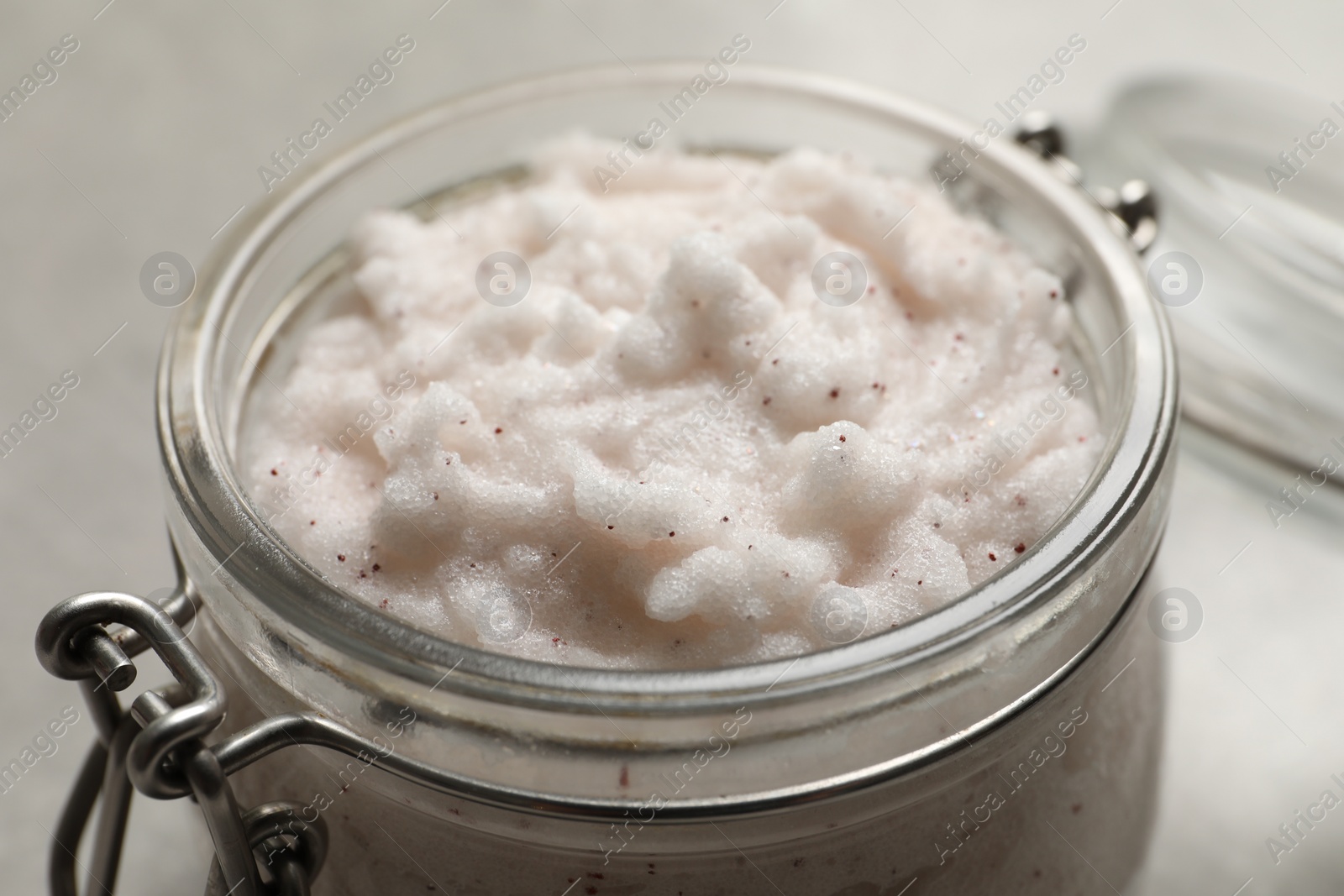 Photo of Body scrub in glass jar on table, closeup