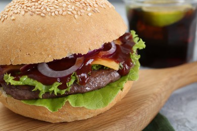 Board with delicious cheeseburger on table, closeup