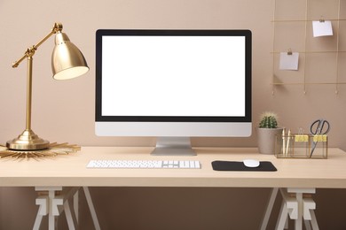 Photo of Stylish workplace with modern computer near beige wall indoors. Space for text