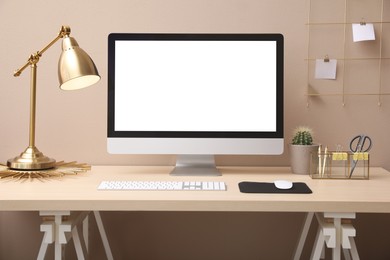 Stylish workplace with modern computer near beige wall indoors. Space for text