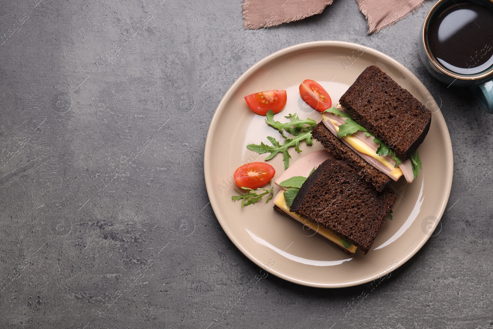 Photo of Delicious sandwiches with boiled sausage, tomato, cheese and arugula on grey table, flat lay. Space for text