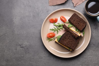 Photo of Delicious sandwiches with boiled sausage, tomato, cheese and arugula on grey table, flat lay. Space for text