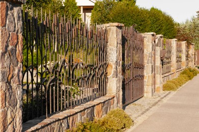 Beautiful iron fence on sunny day outdoors