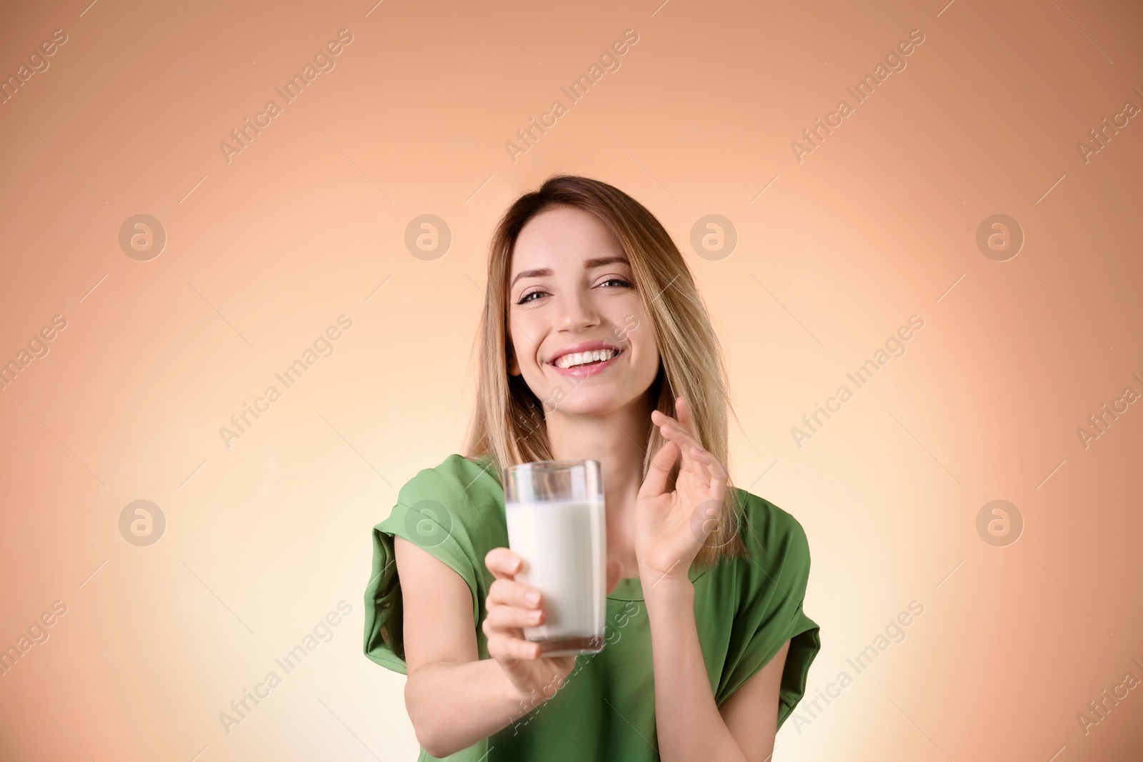 Photo of Beautiful young woman drinking milk on color background