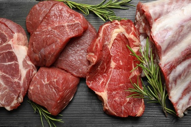 Flat lay composition with fresh meat on black wooden table