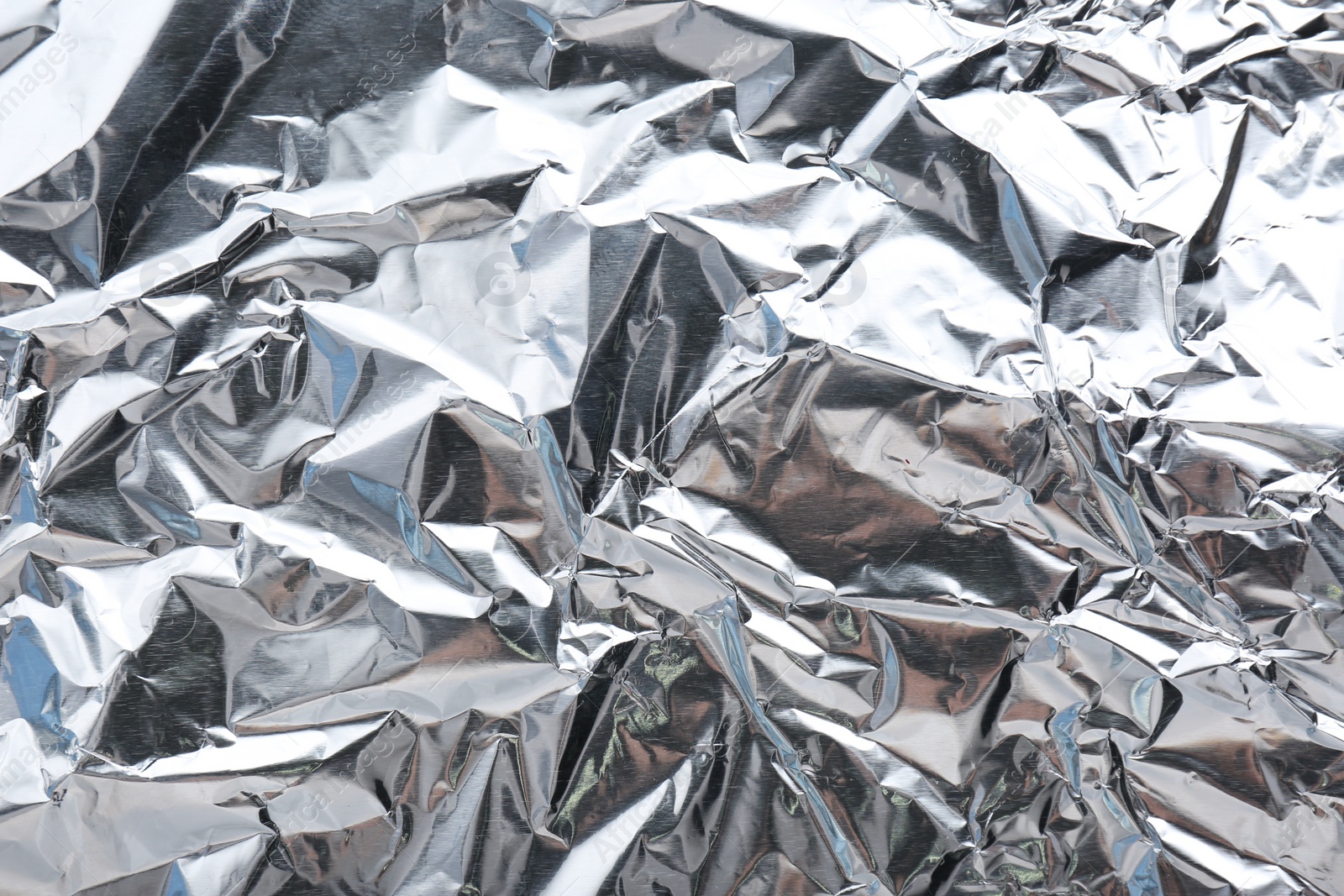 Photo of Crumpled silver foil as background, closeup view