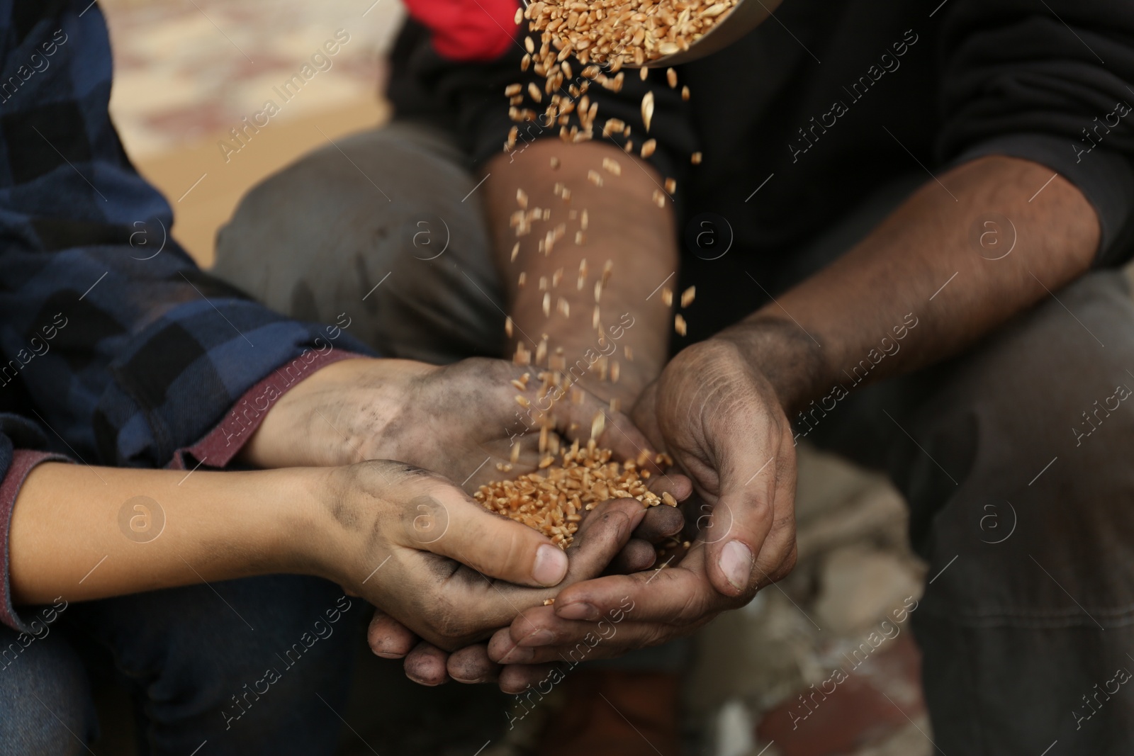 Photo of Poor homeless people taking wheat from donator outdoors, closeup