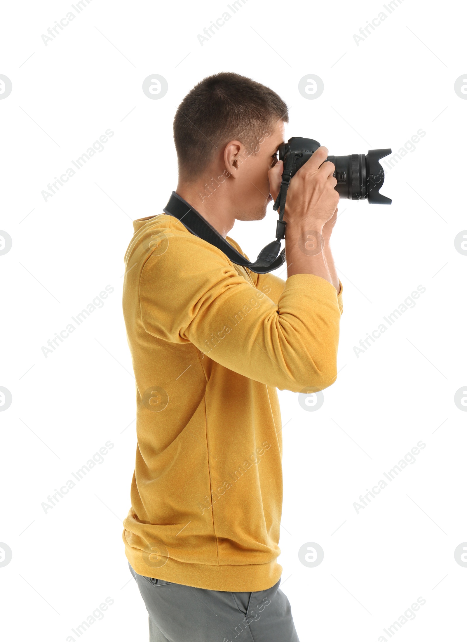 Photo of Young professional photographer taking picture on white background