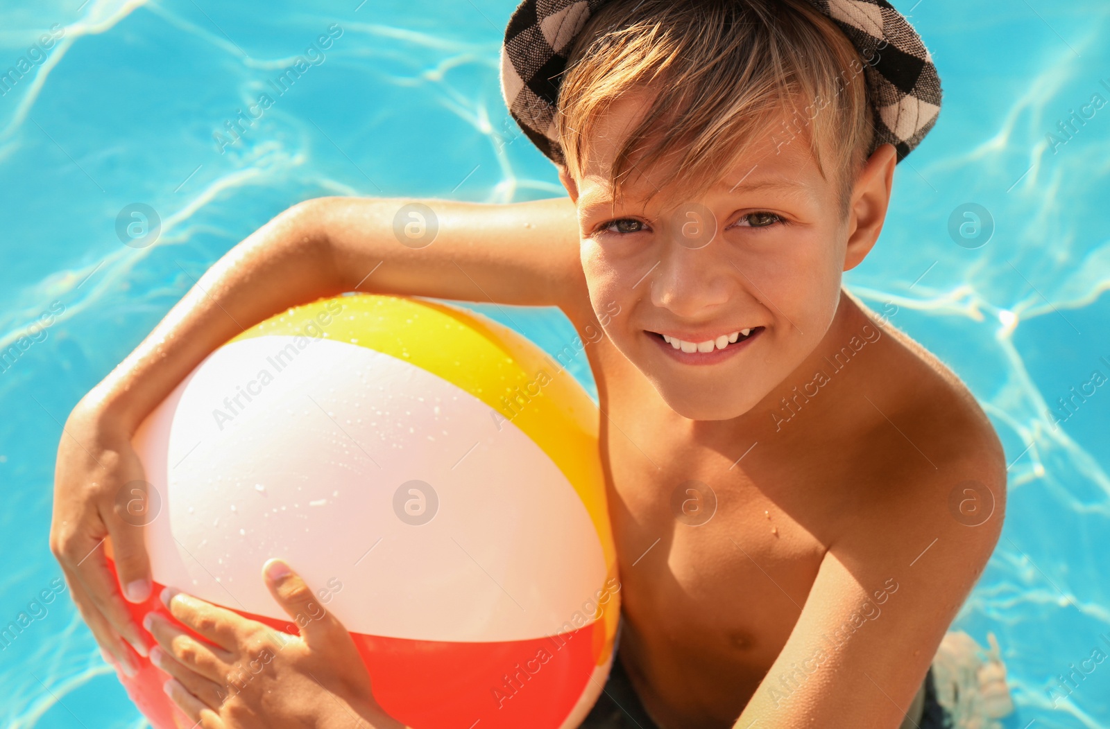 Photo of Happy cute boy with inflatable ball in swimming pool