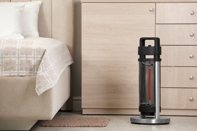 Modern infrared heater on floor in bedroom