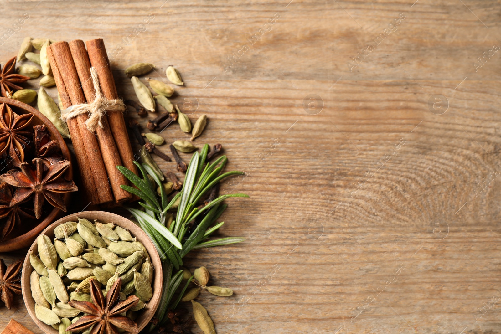 Photo of Flat lay composition with mulled wine ingredients on wooden table. Space for text