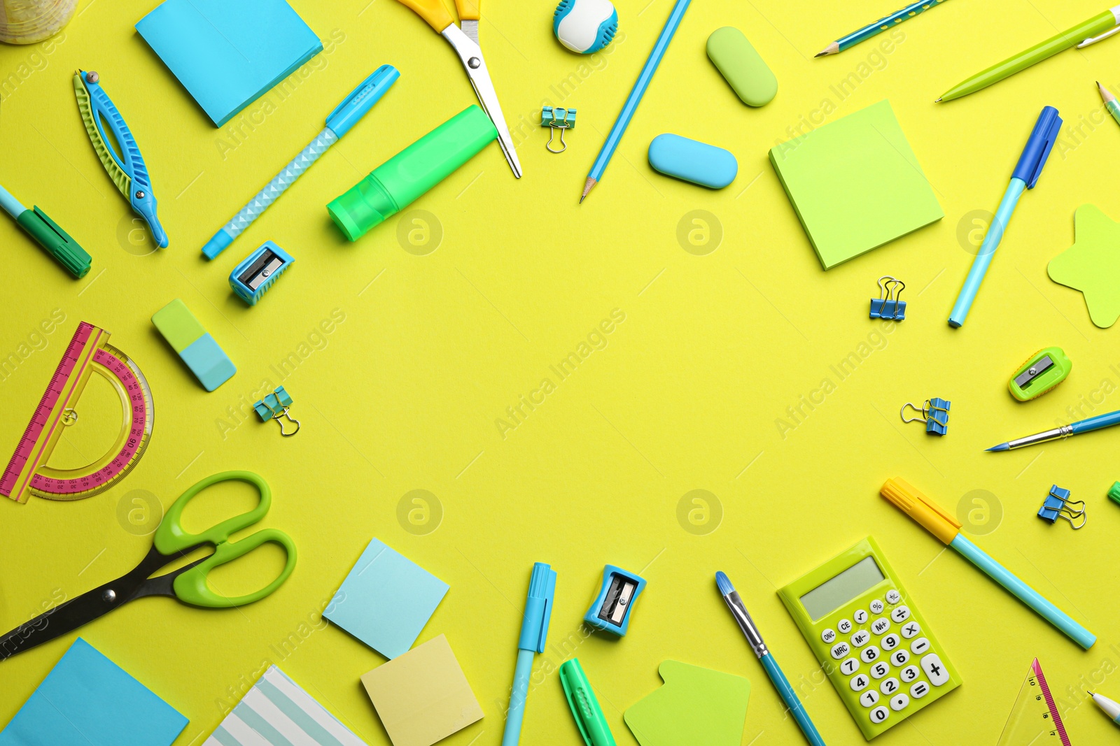 Photo of Frame of different school stationery on yellow background, flat lay with space for text. Back to school
